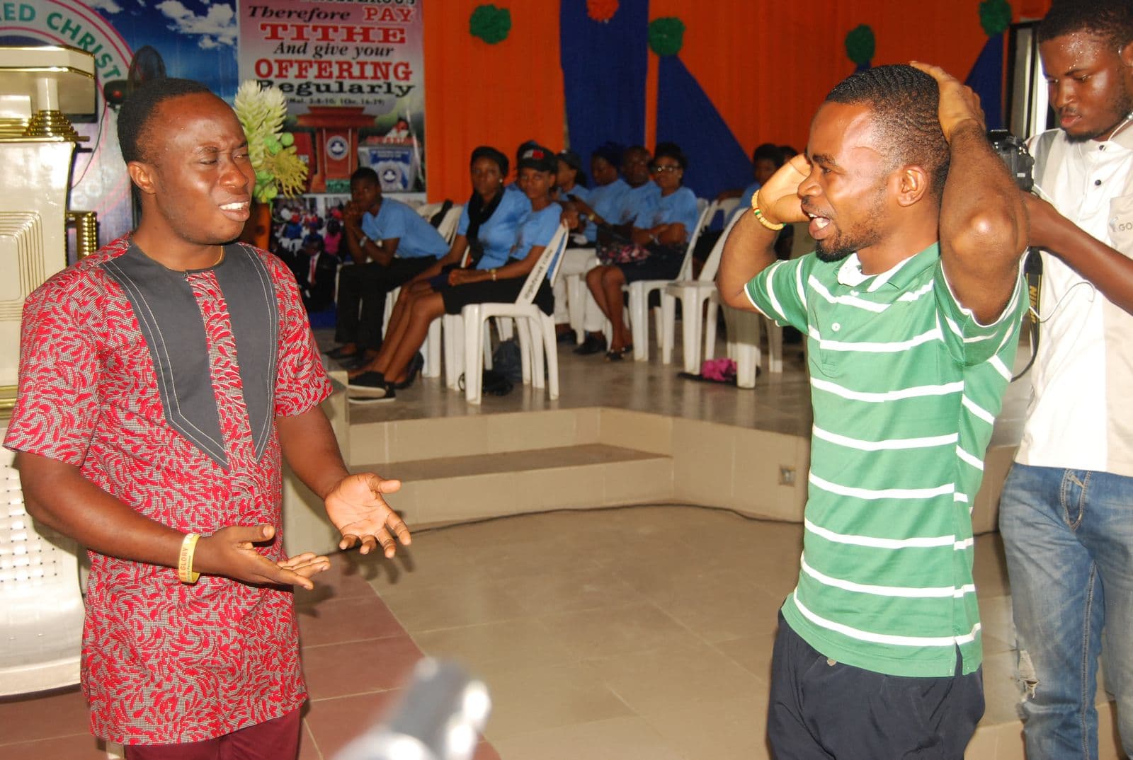 Two singers in patterned shirts sharing a candid moment after ministering.
