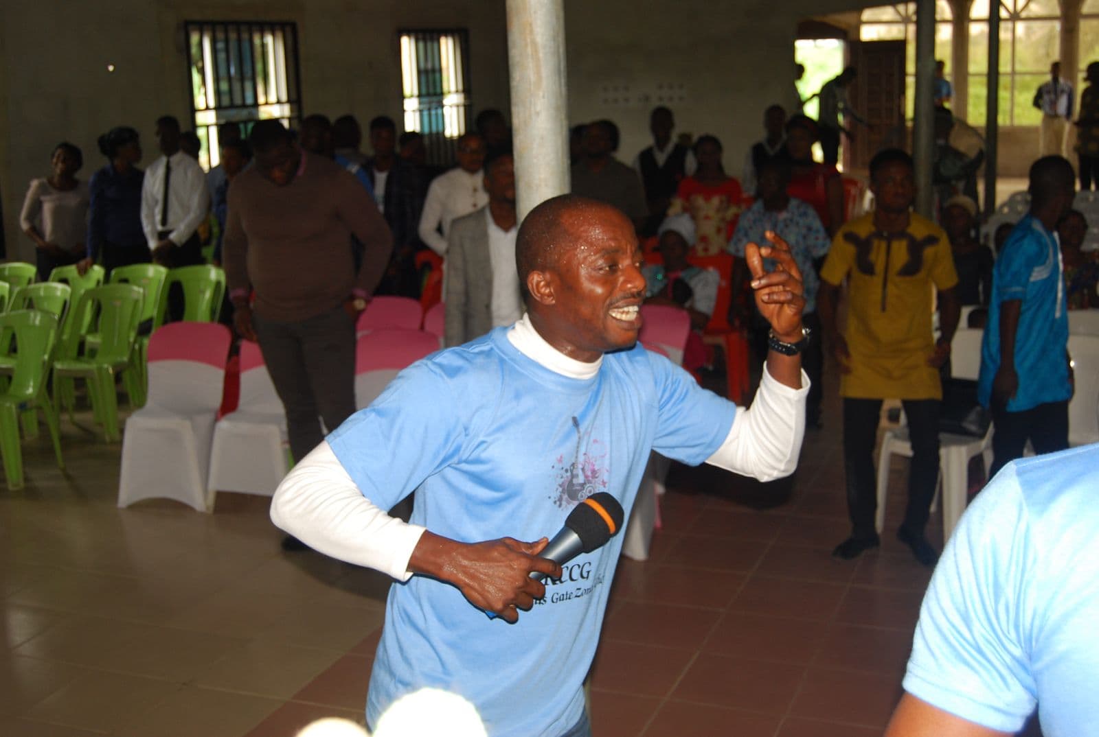 The choir leader addressing the congregation, mid-gesture.
