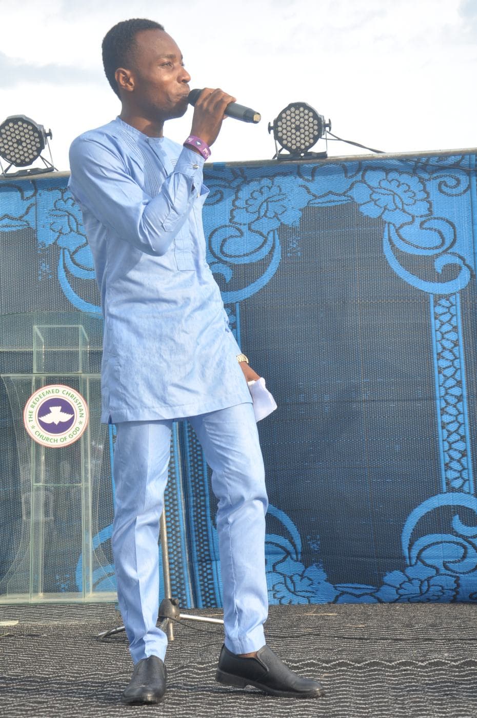 A minister addressing the crowd outdoors.