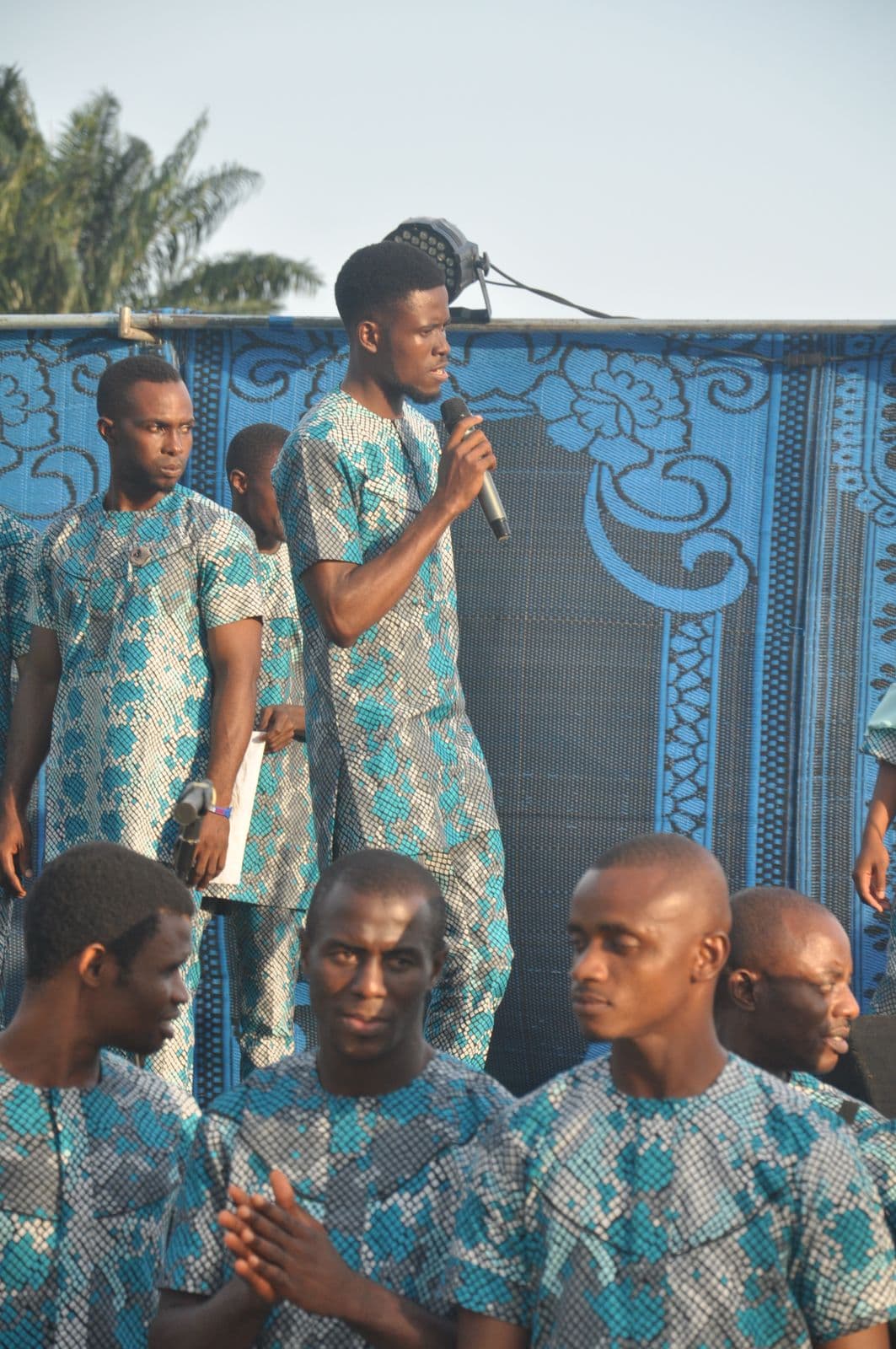 A soloist singing on stage against the event backdrop.