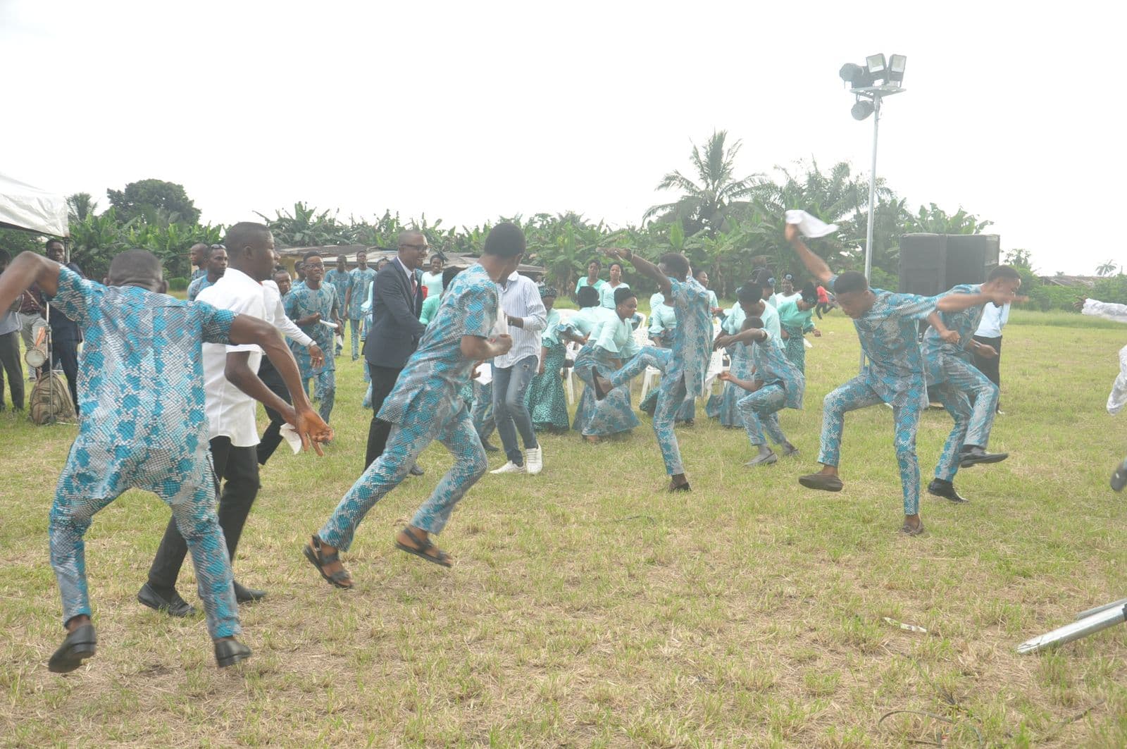 The full company dancing together on the field.