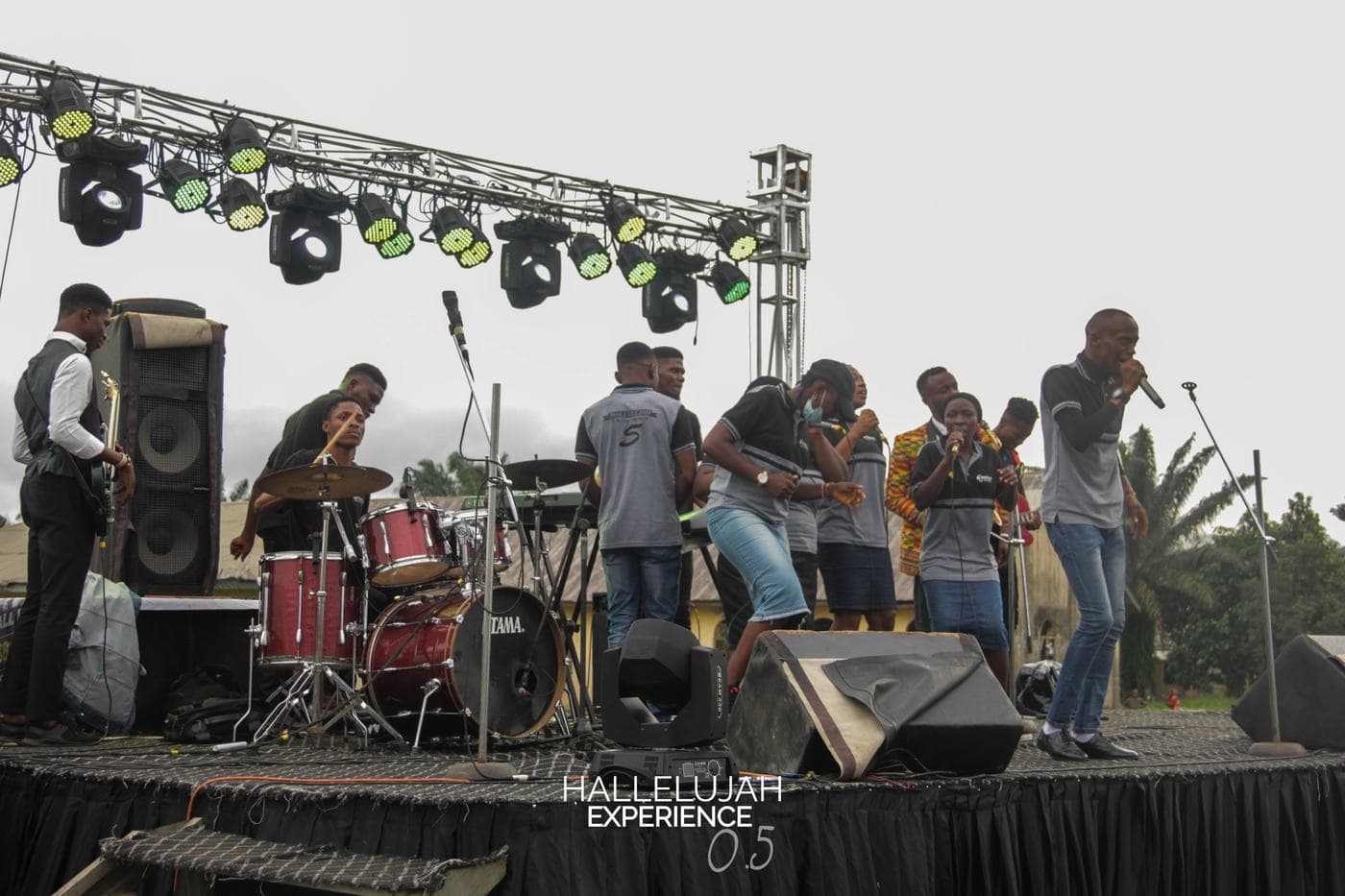 Worshippers with hands raised in the open field.