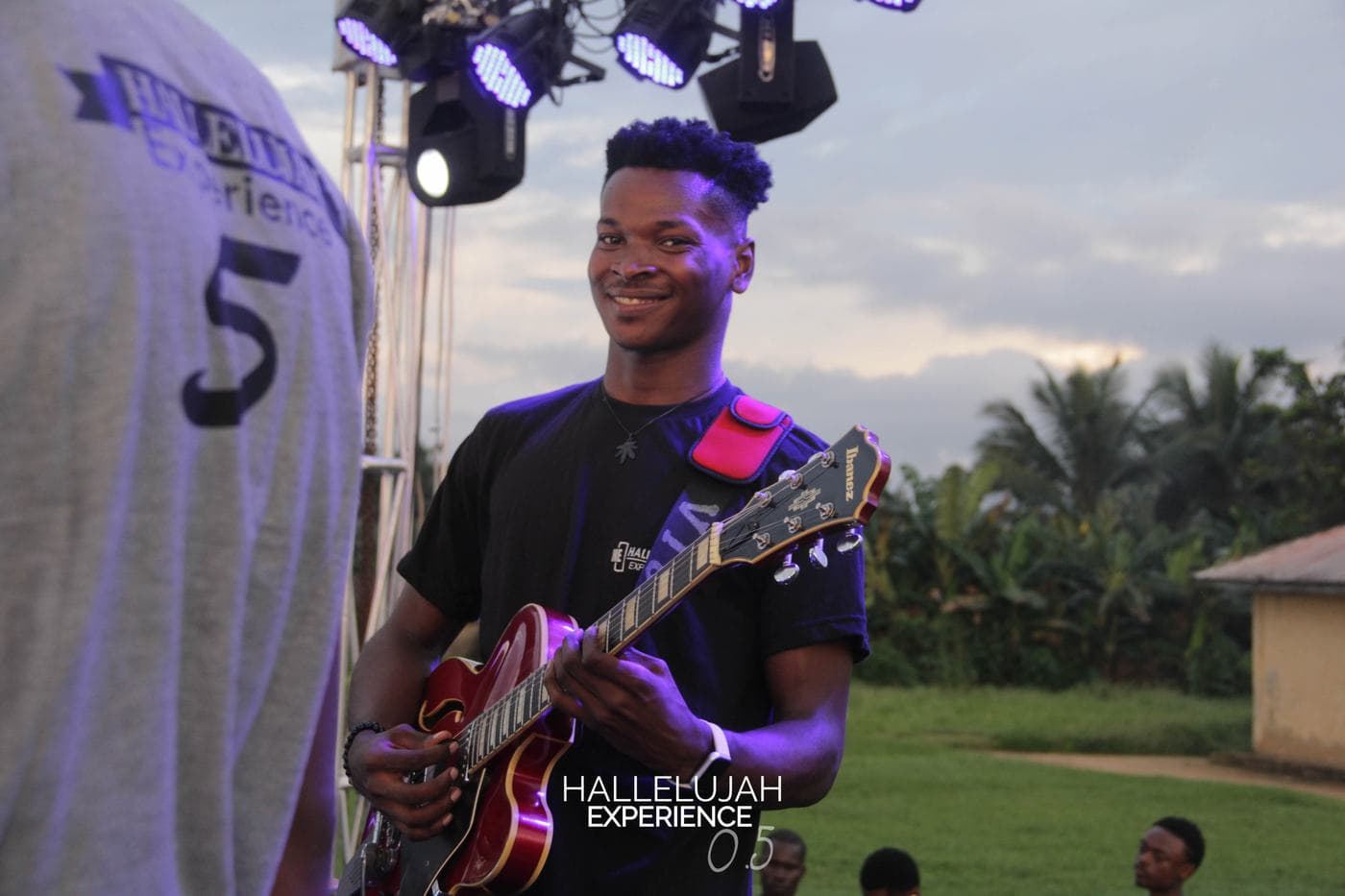 A musician playing under coloured stage light.
