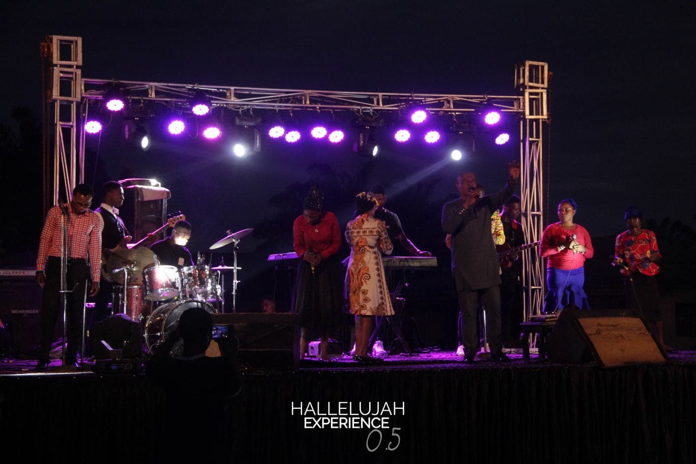 A soloist performing under stage light at night.