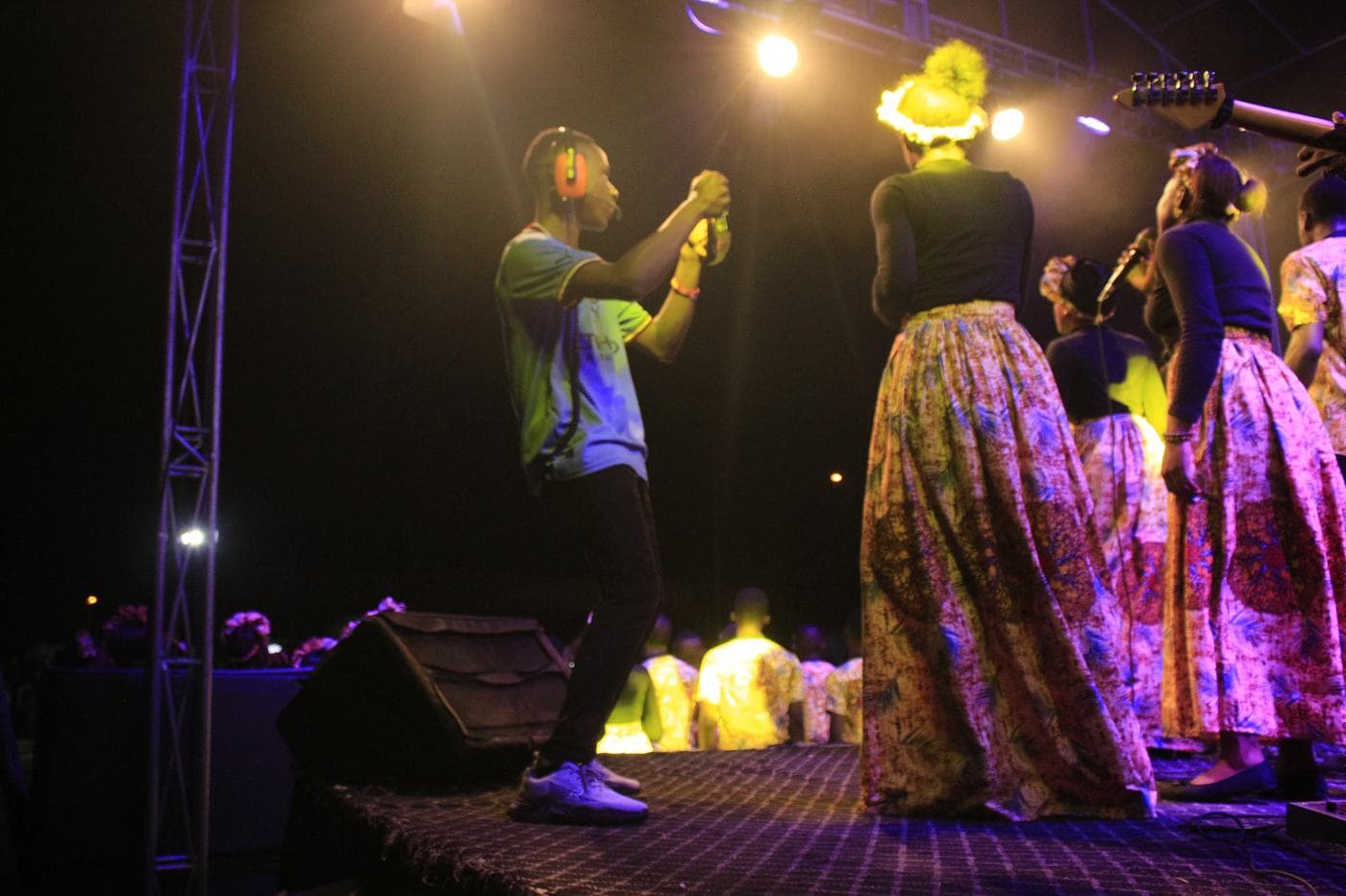 A worshipper with a hand raised at night.
