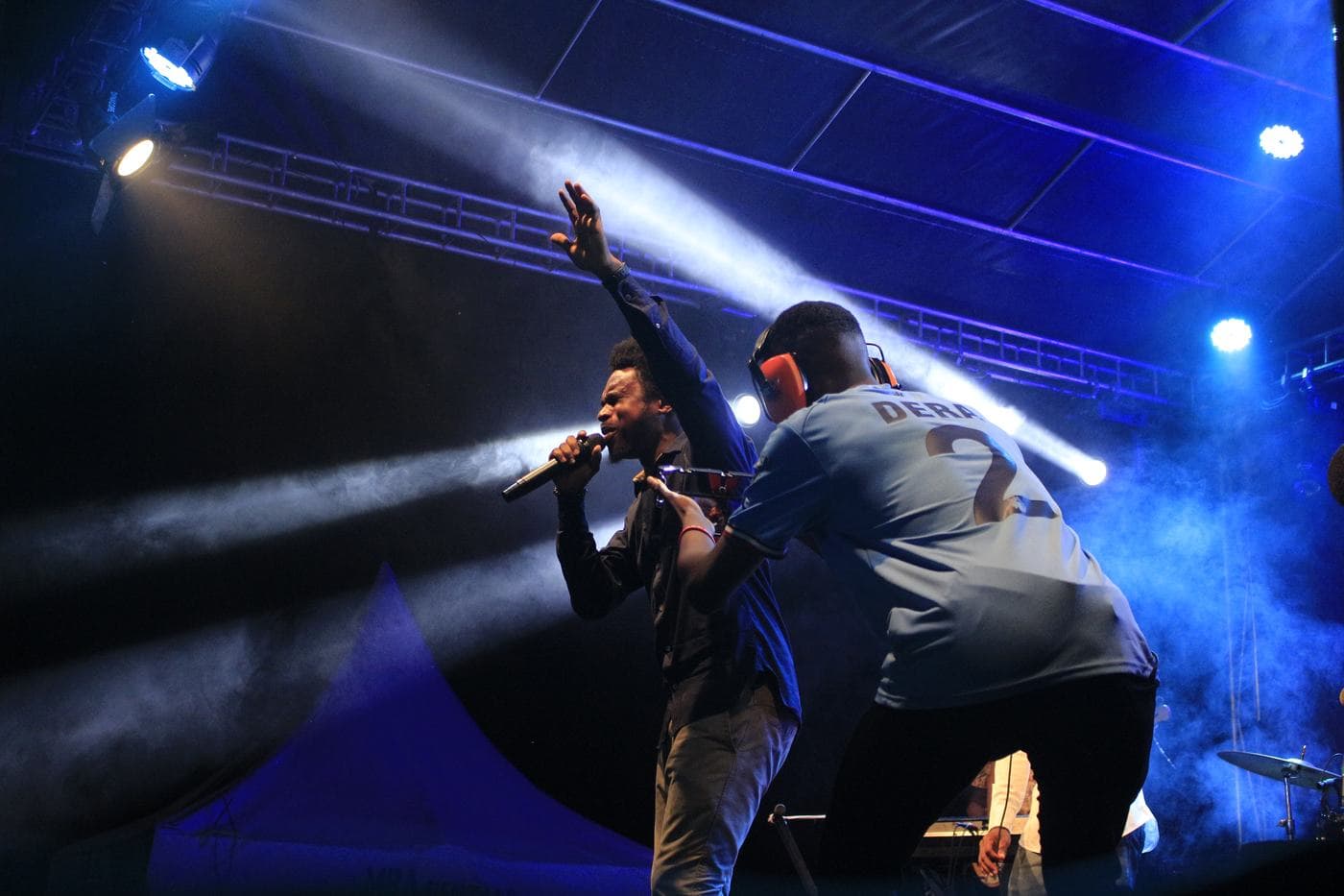 A soloist singing into a handheld microphone at night.