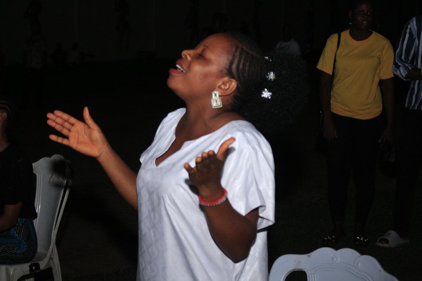 A member of the band playing under stage light.