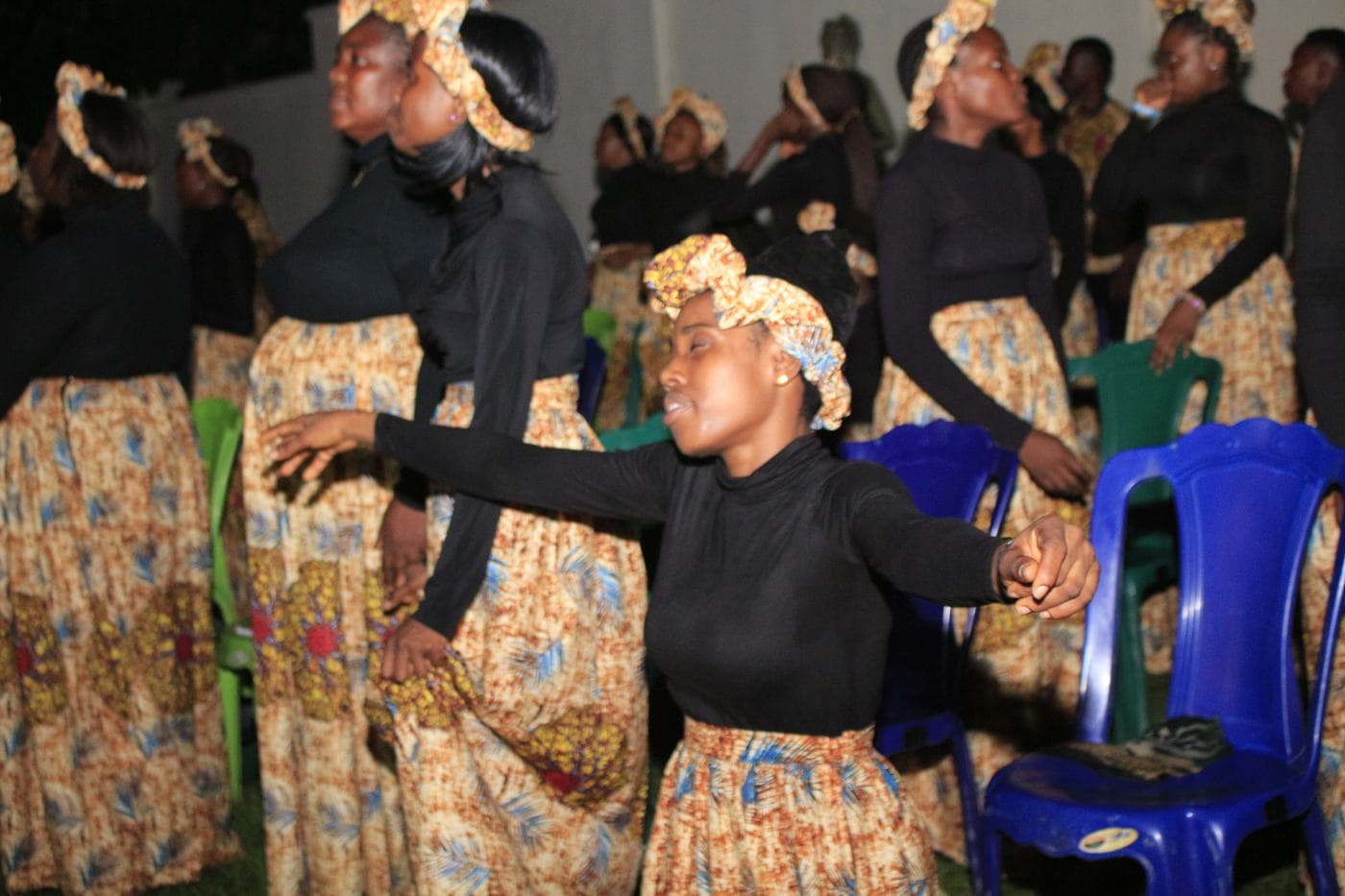 The choir singing together under coloured light.