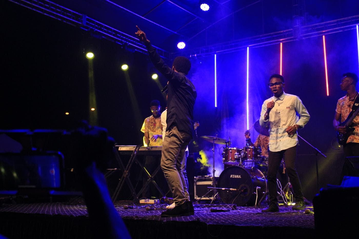 A worshipper with a hand raised at night.