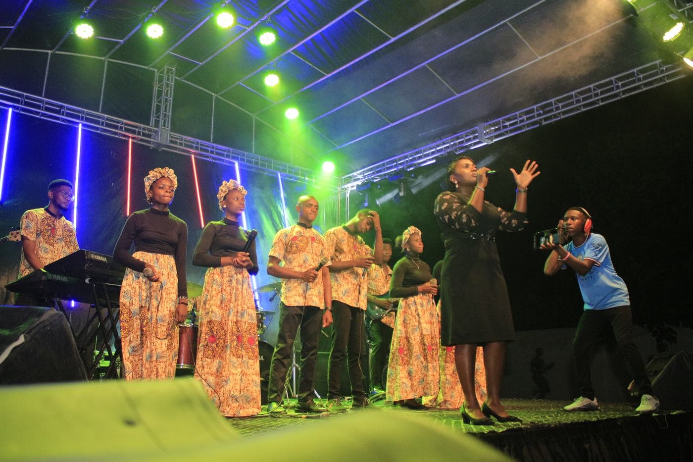 A worshipper with a hand raised at night.