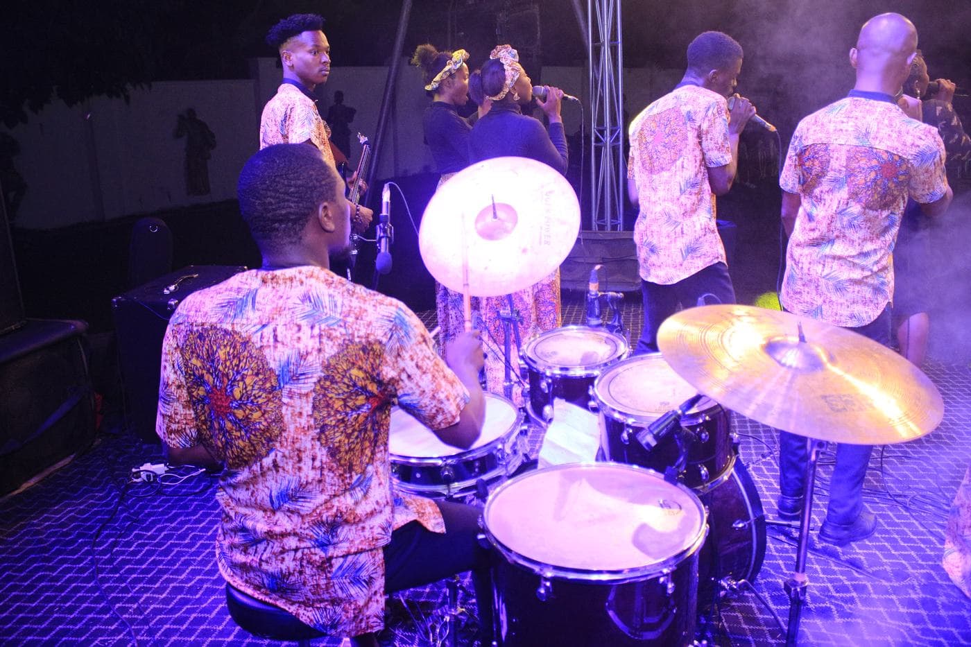 The choir singing together under coloured light.