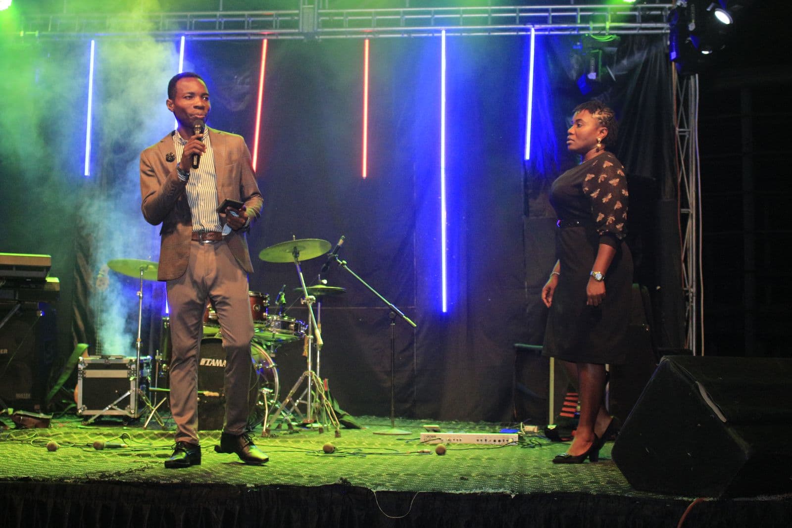A minister speaking on stage beside a co-host.