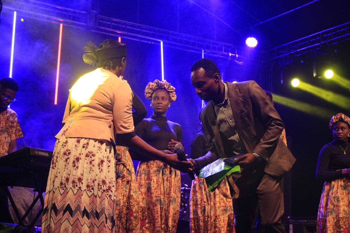 A worshipper with a hand raised at night.