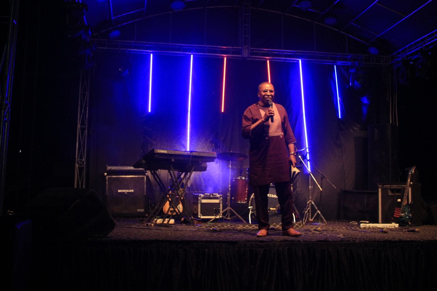 A worshipper with a hand raised at night.