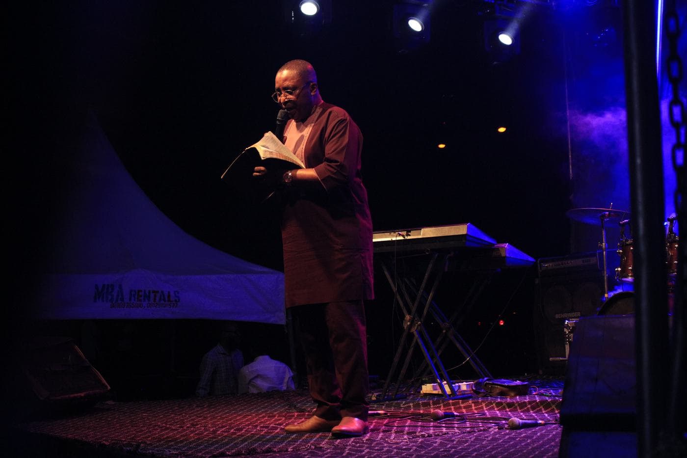A soloist singing into a handheld microphone at night.