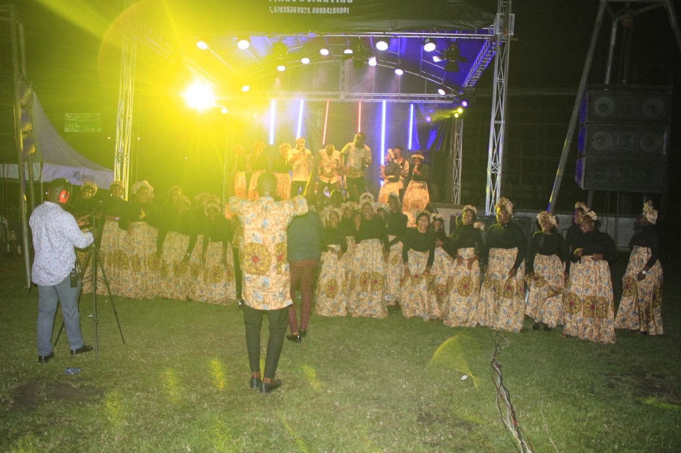 A member of the band playing under stage light.