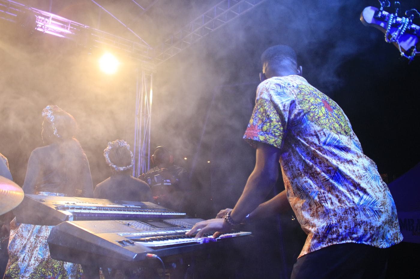 A worshipper with a hand raised at night.