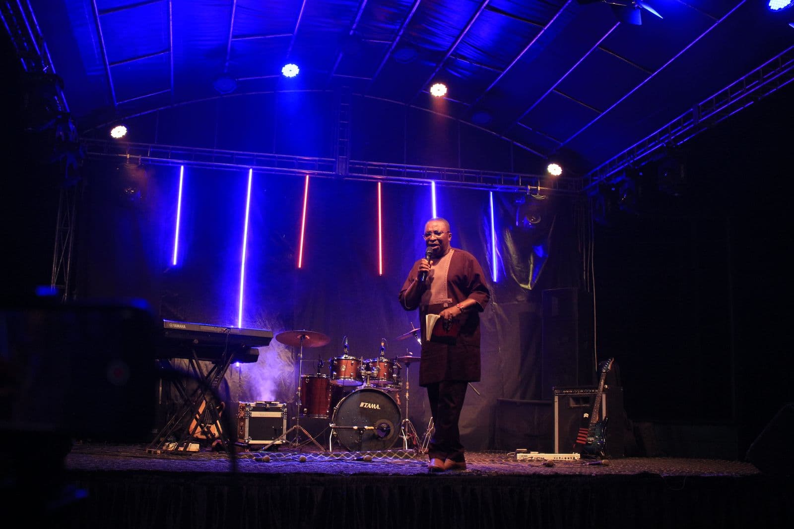 The stage and lighting rig at night, a minister addressing the crowd.