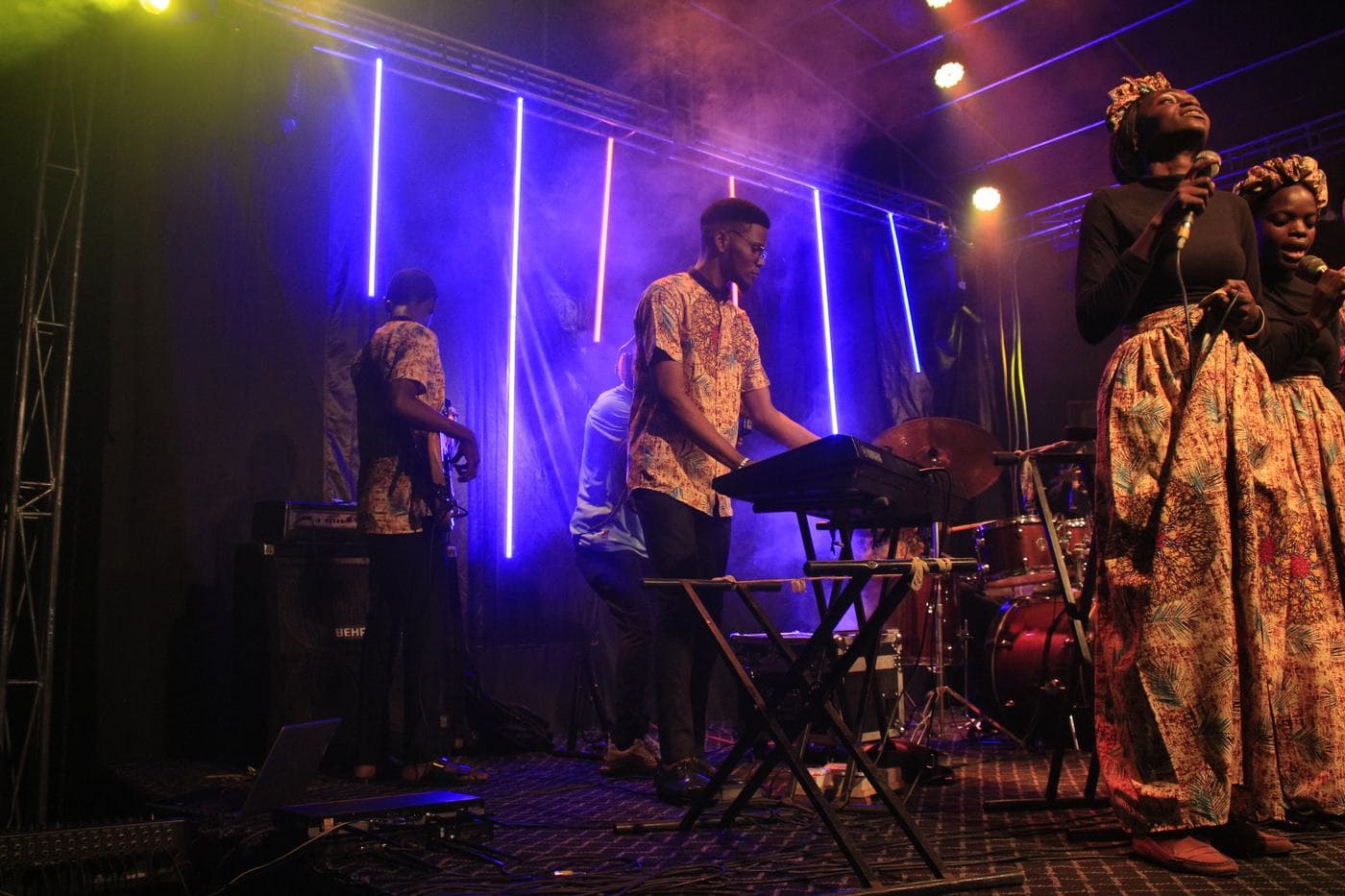 A member of the band playing under stage light.