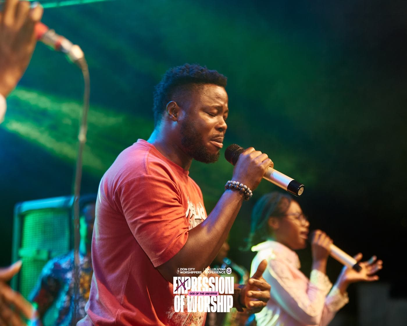 A member of the band performing under blue stage light.