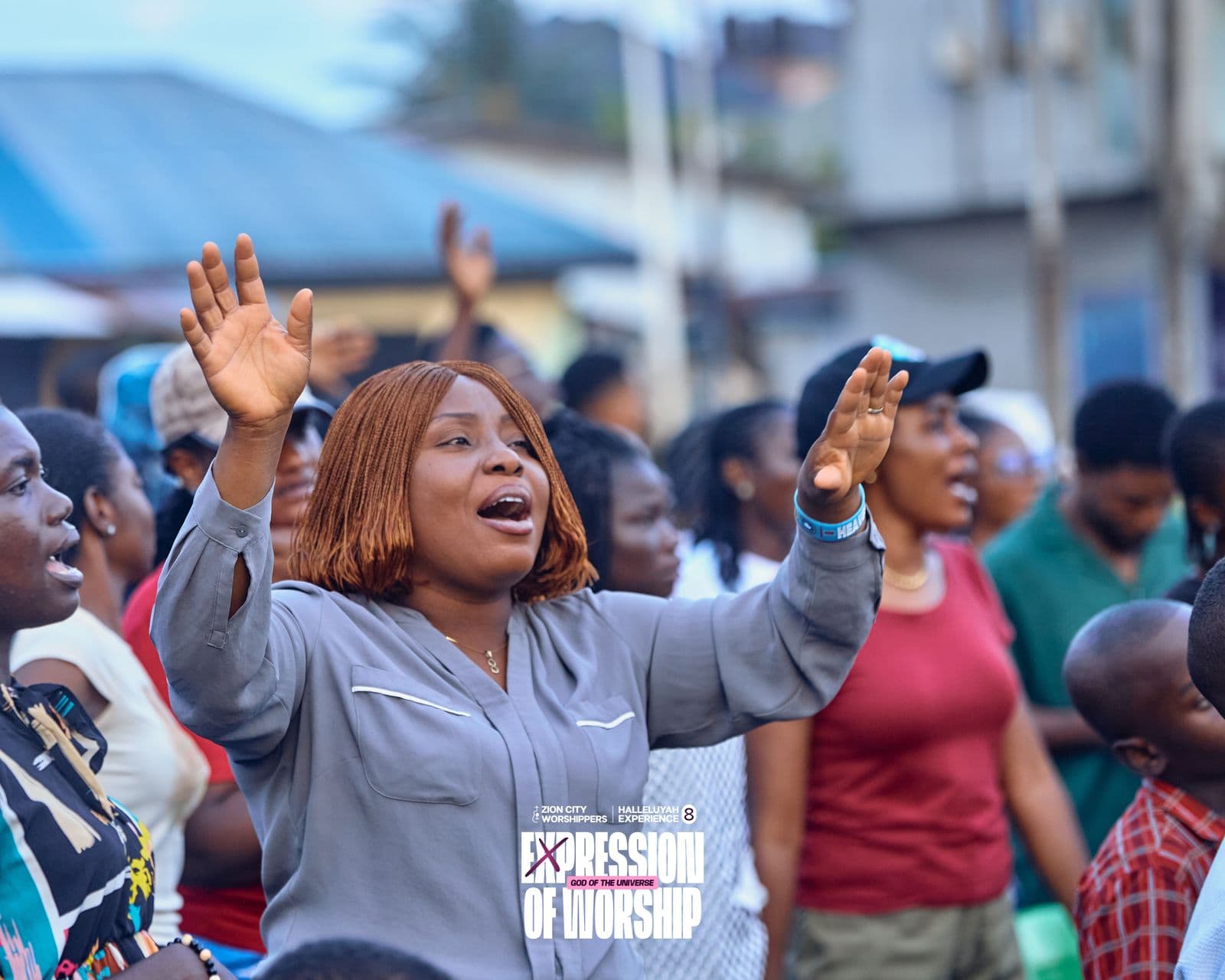 The crowd worshipping with hands raised at dusk.