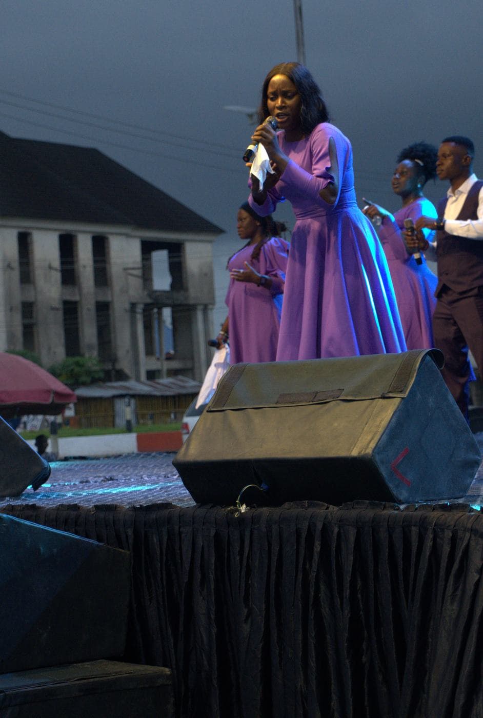 A worshipper at night, the stage lit behind.