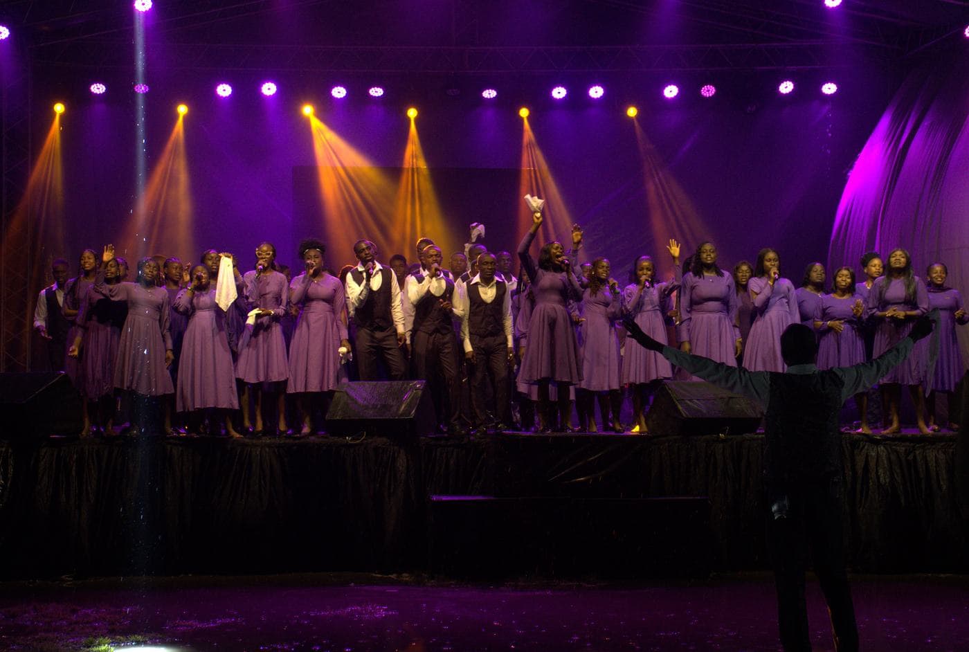 A soloist performing under coloured stage light.