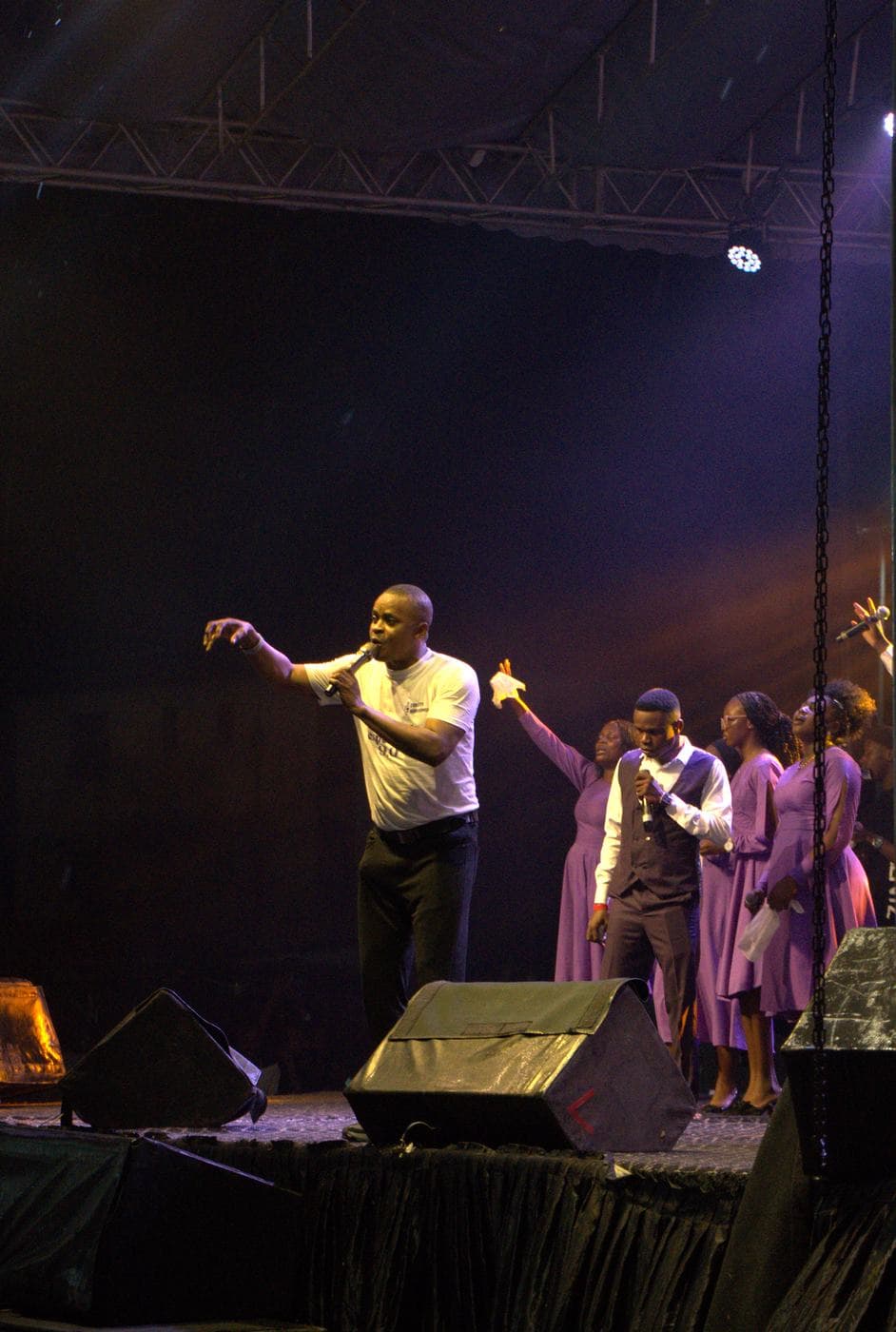 The choir performing together under purple stage light.