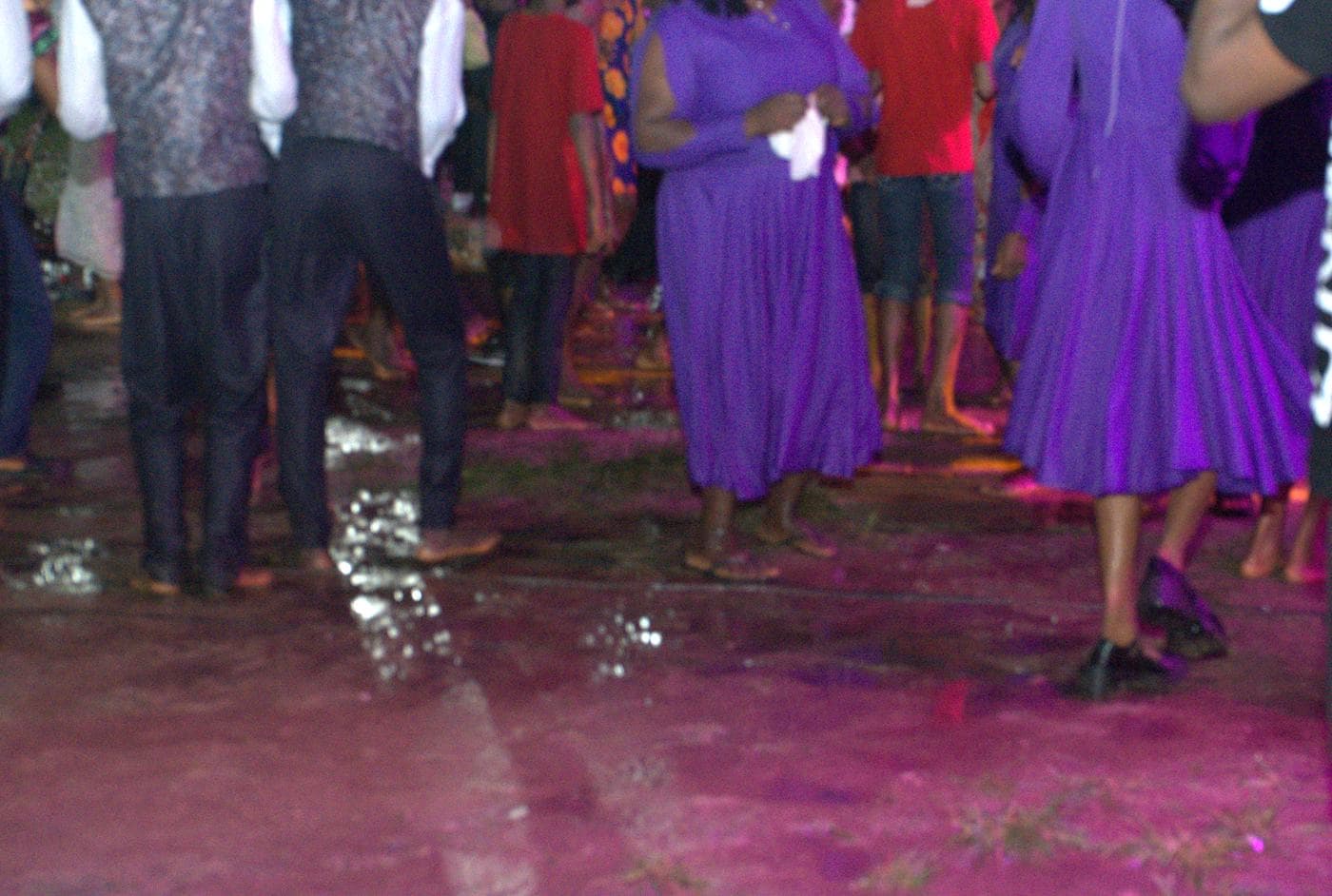 A worshipper at night, the stage lit behind.
