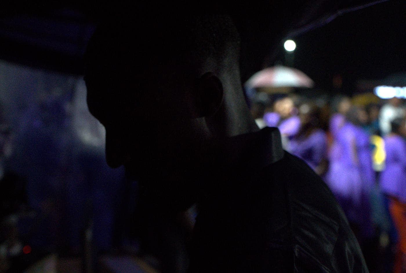 A soloist performing under coloured stage light.