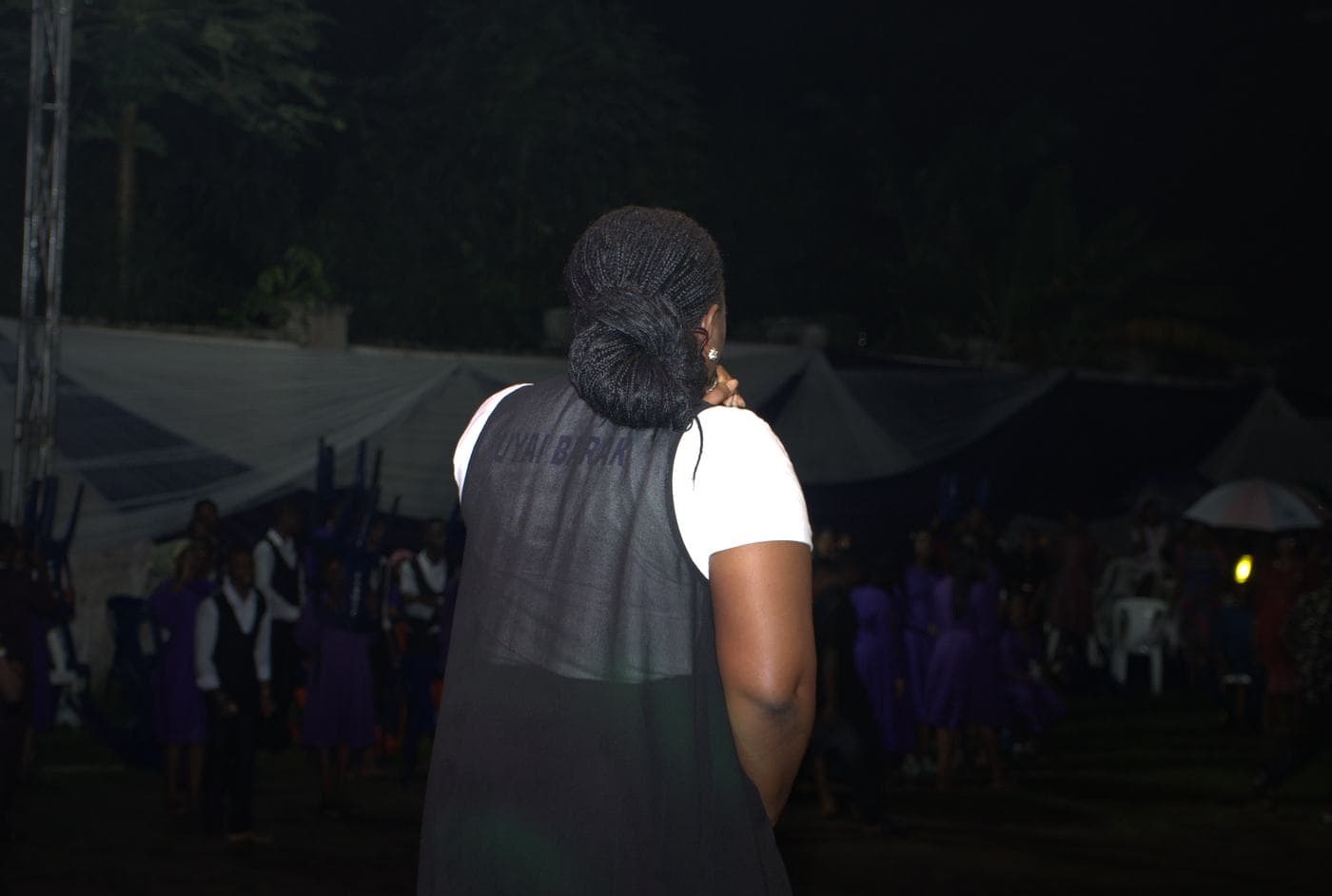 A soloist singing beneath the "Take all the Glory" backdrop.