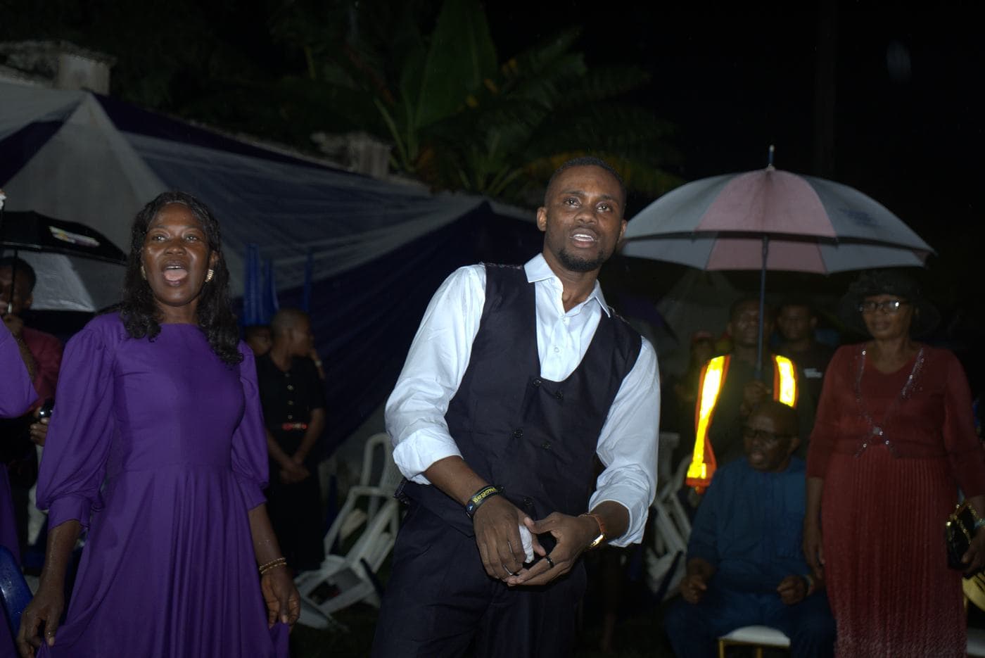 A worshipper at night, the stage lit behind.