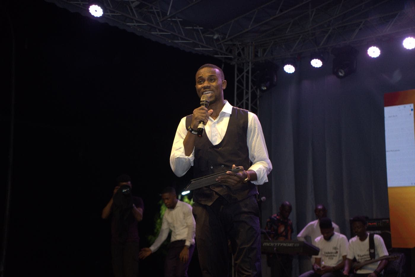 A soloist performing under coloured stage light.