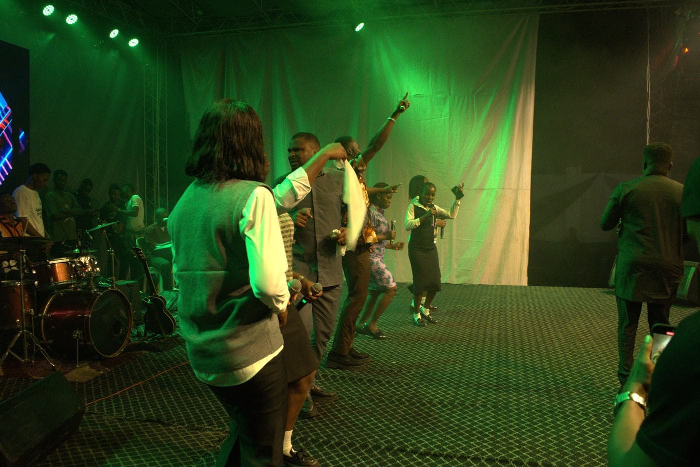 A worshipper at night, the stage lit behind.