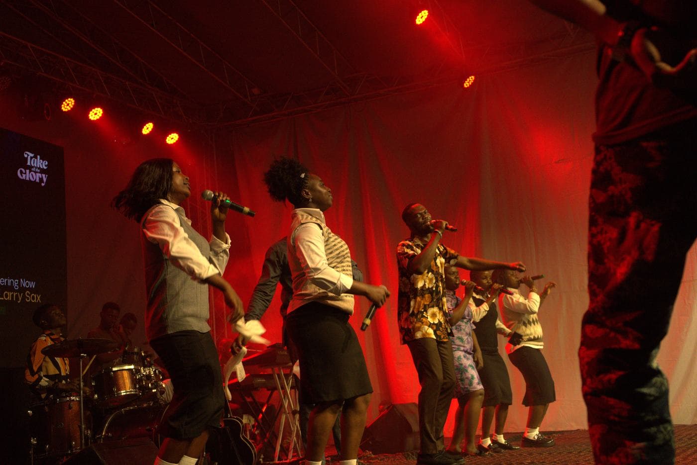 A soloist performing under coloured stage light.