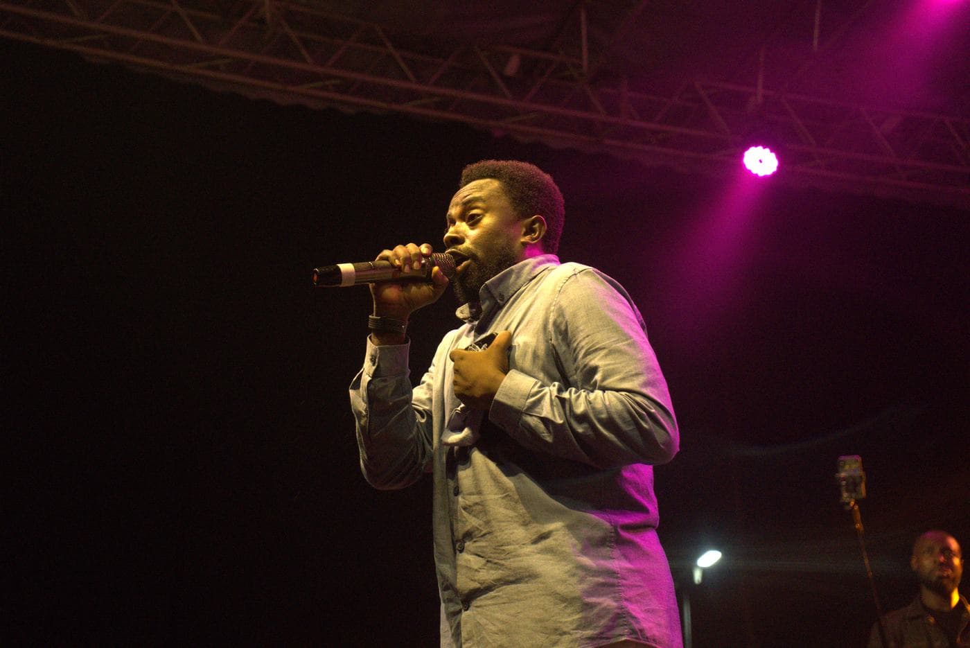 A worshipper at night, the stage lit behind.