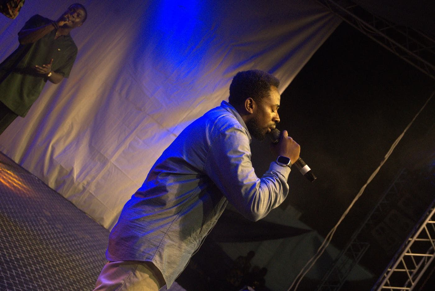A soloist performing under coloured stage light.