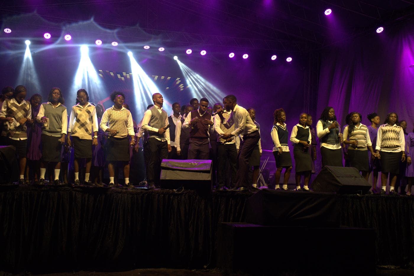 A worshipper at night, the stage lit behind.