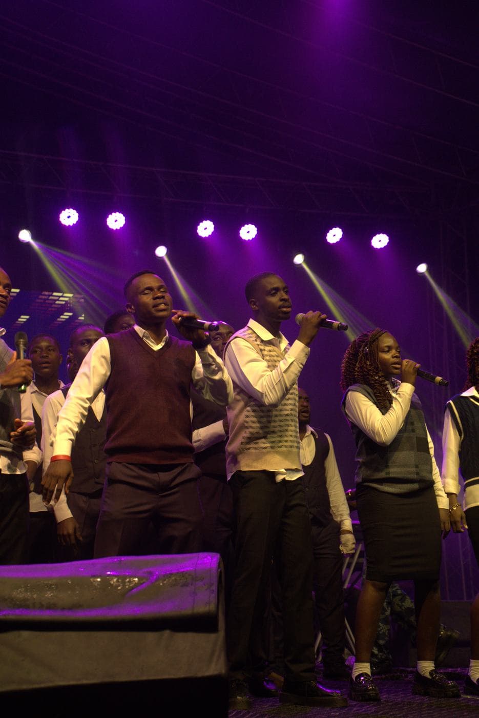 A soloist performing under coloured stage light.