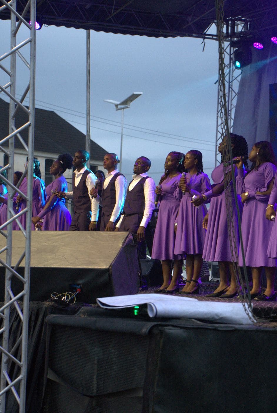 A soloist singing beneath the "Take all the Glory" backdrop.