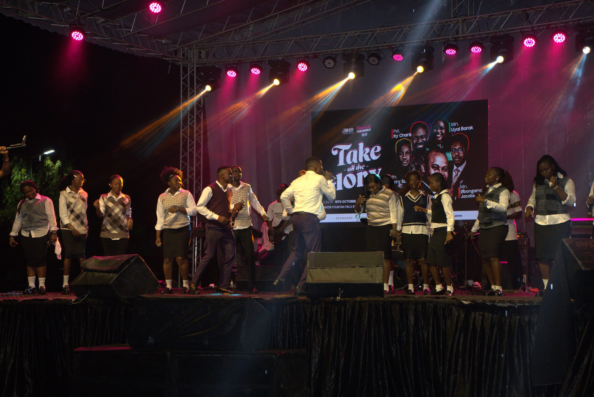 The choir performing beneath the "Take All Glory" stage backdrop.